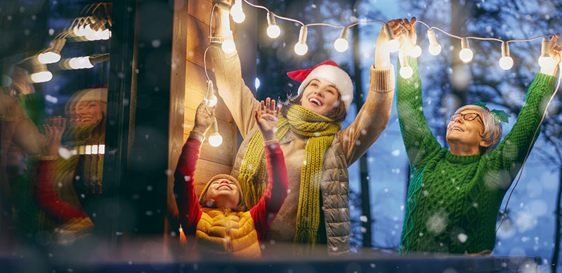 mother, daughter and grandmother hanging lights
